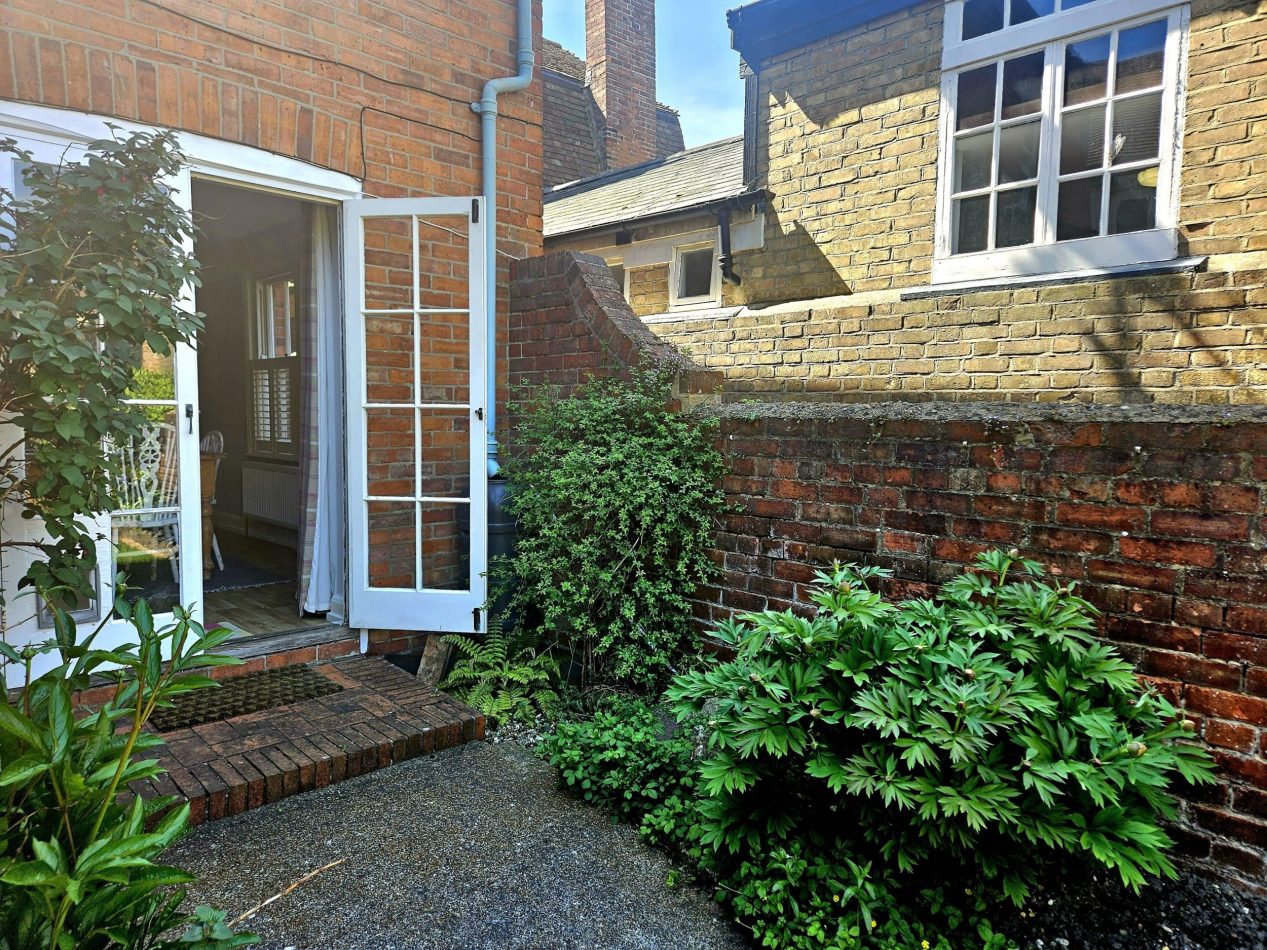 Patio doors open from the dining room onto a private brick patio and garden - ideal for indoor-outdoor living at this Hythe holiday home, just minutes from the beach, canal walks and high street.
