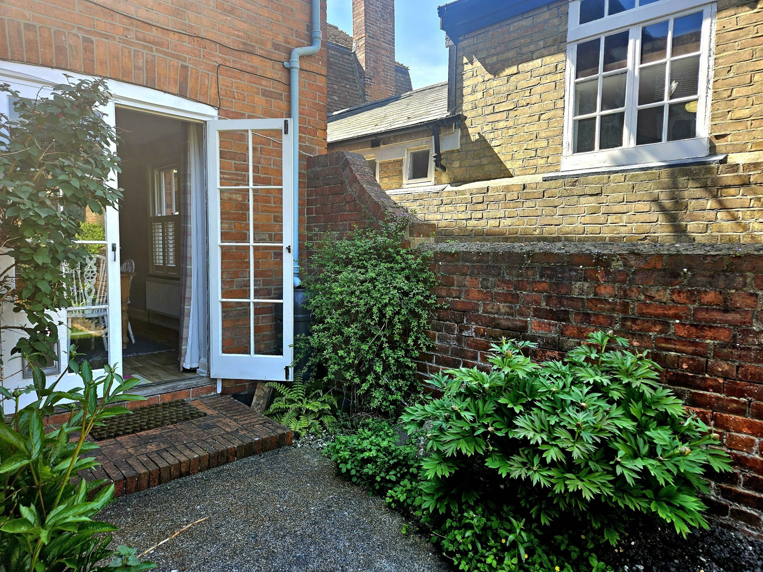 Patio doors open from the dining room onto a private brick patio and garden - ideal for indoor-outdoor living at this Hythe holiday home, just minutes from the beach, canal walks and high street.