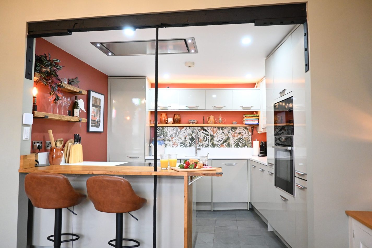 Your kitchen is styled with warm terracotta tones, creating a cosy, inviting feel, while the breakfast bar with stools is perfect for morning coffee, casual dining or relaxed evenings in your central Sandwich apartment.