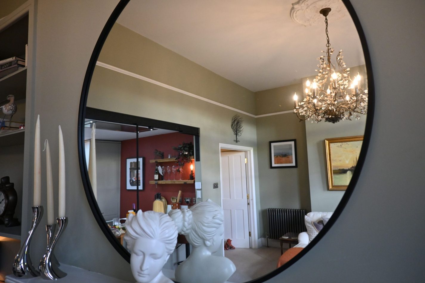 A large mirror above your fireplace reflects light from your floor-to-ceiling windows, enhancing the sense of space and brightness in your stylish central Sandwich apartment.