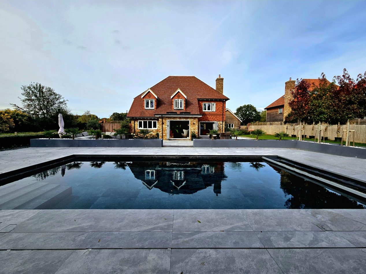 Take in the rear view of the house with the outdoor heated pool set in front, surrounded by generous grounds. A stunning backdrop for summer stays, group getaways and luxury holiday living in Kent.