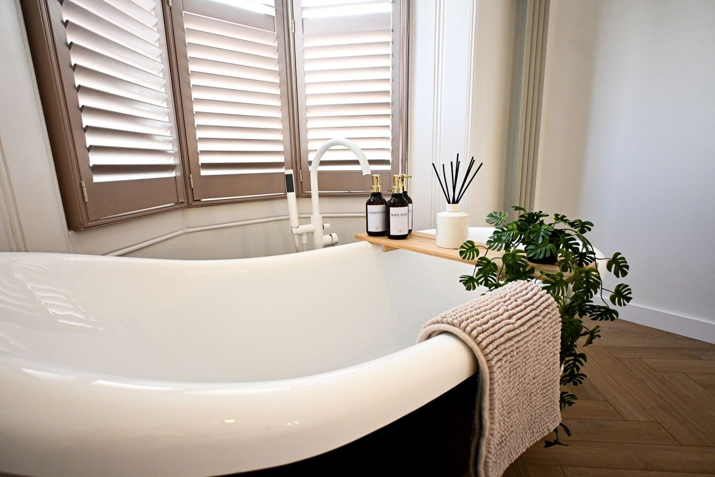 Start your morning slowly with a coffee beside the freestanding roll-top bath, beautifully positioned within this luxurious bedroom suite. Framed by elegant shutters and filled with natural light, it's a boutique-style retreat unlike anything else in Rams