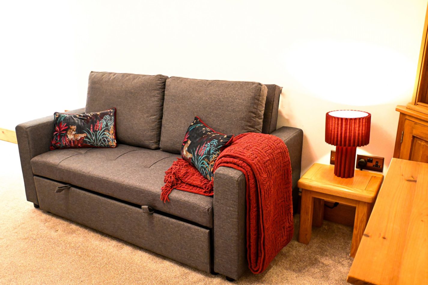 Relax on the comfortable sofa with a warm throw and countryside views nearby; it converts into a bed for up to two additional guests.