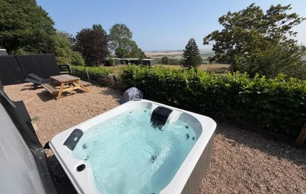 Sink into your private hot tub and enjoy the bubbles while looking across the peaceful garden, surrounding countryside and distant sea.
