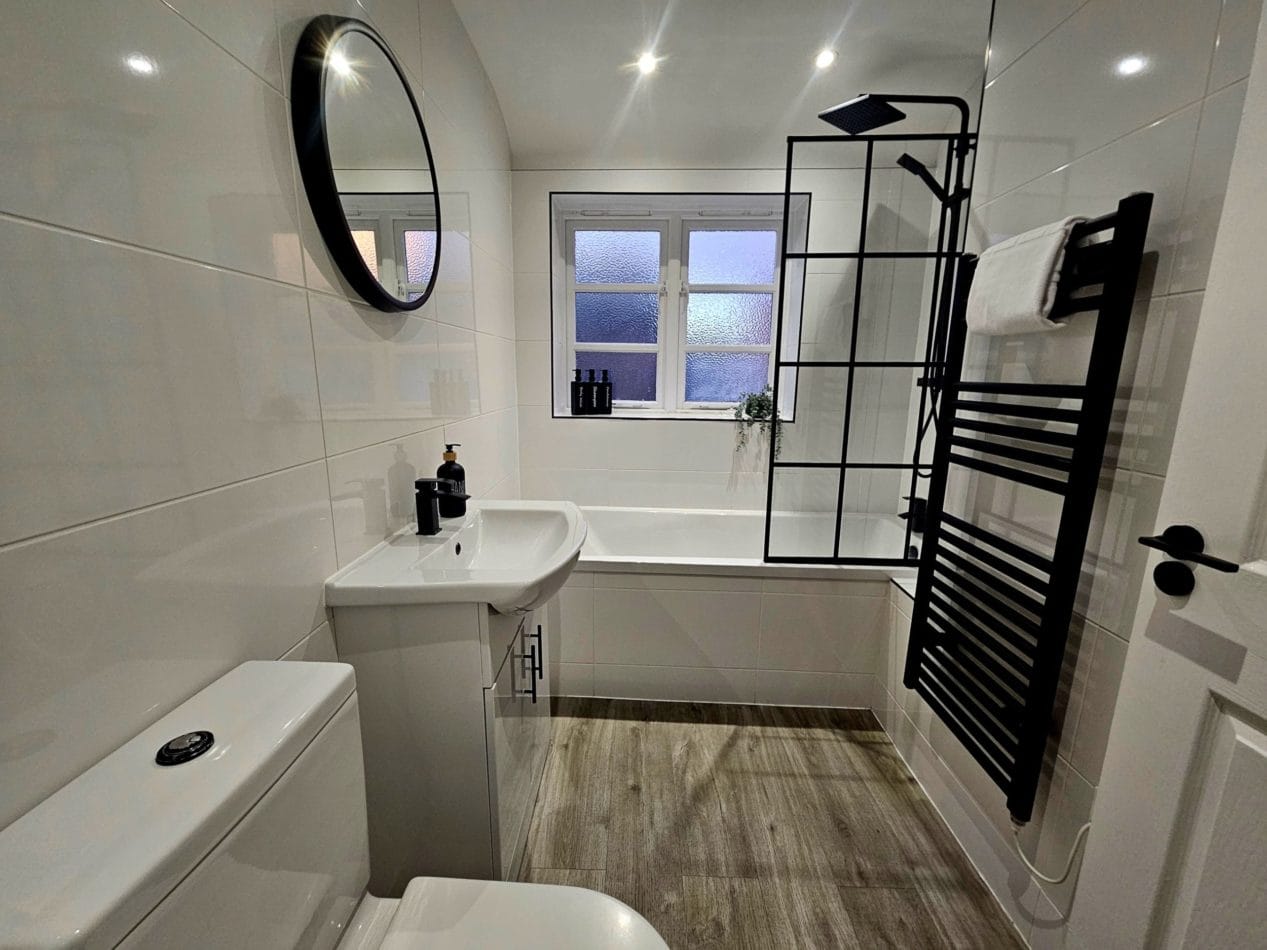 Modern bathroom with bath and shower over, offering guests the convenience of both options during their stay. A clean, practical space designed for comfortable everyday living when working away from home.