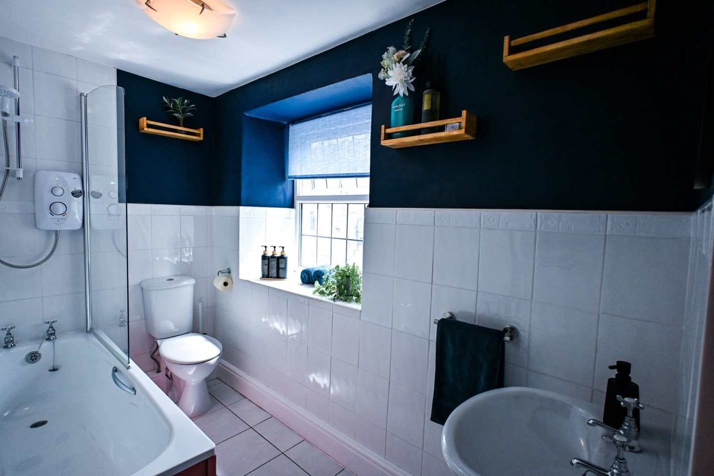 The family bathroom has a full size bath with a show over.