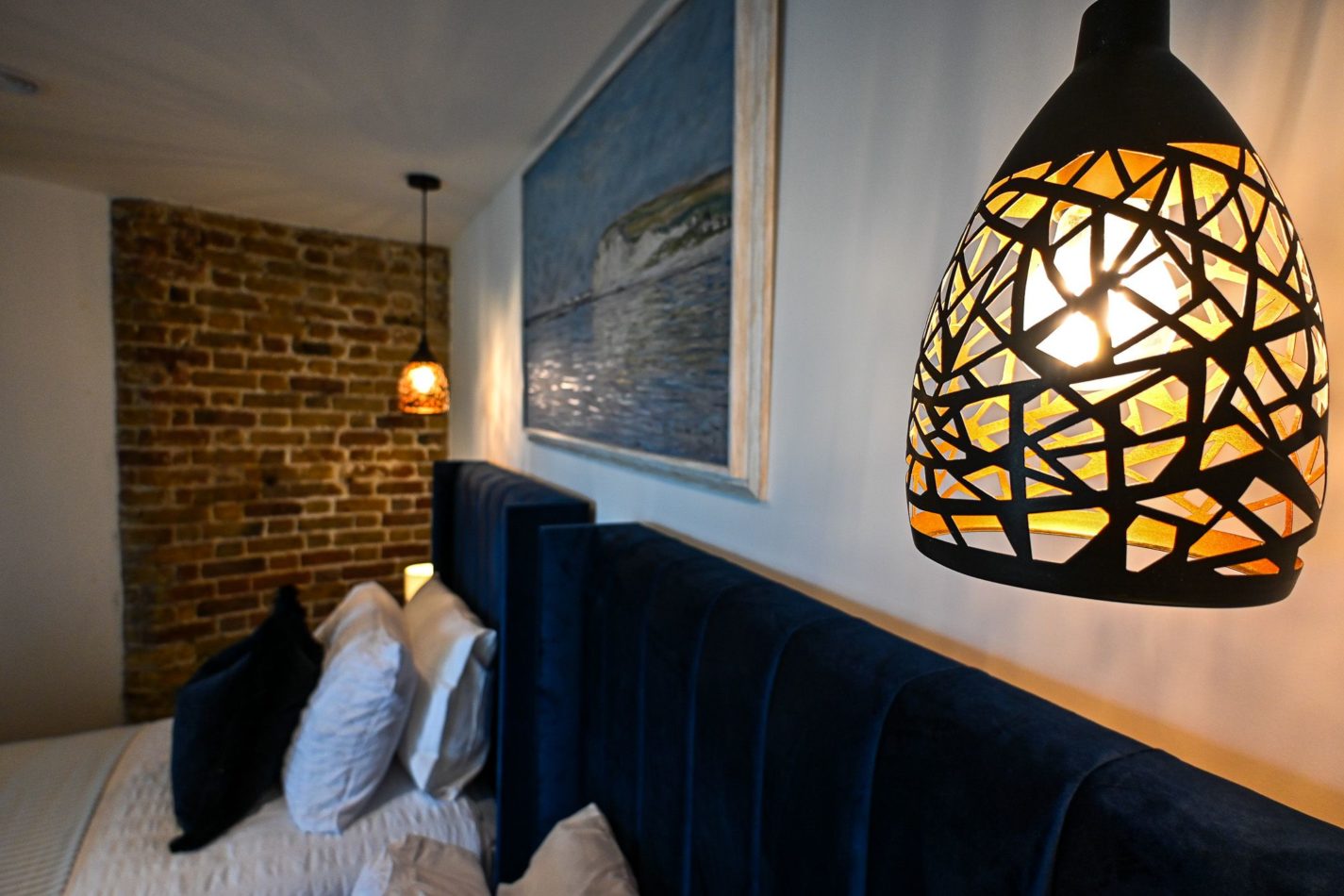 Nothing cookie-cutter here. Deep blue upholstery, atmospheric lighting and original brickwork give each bedroom its own personality while keeping the warmth and character of the tower at its heart.