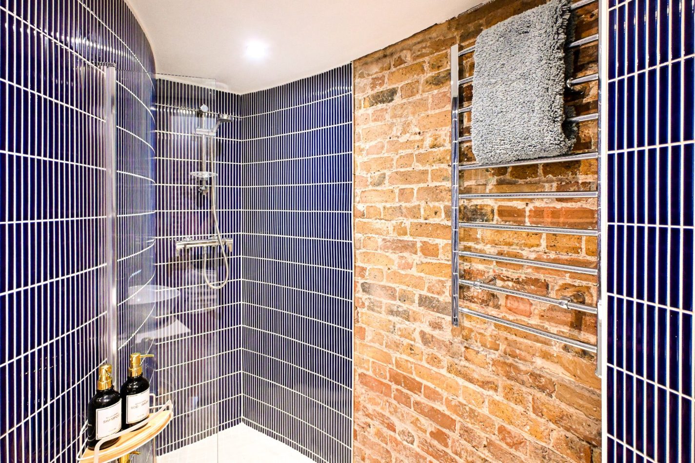 Imagine coming back sandy and windswept from the beach and stepping straight into this. A spacious modern shower sits alongside the tower’s original exposed brick — practical, luxurious and full of character.