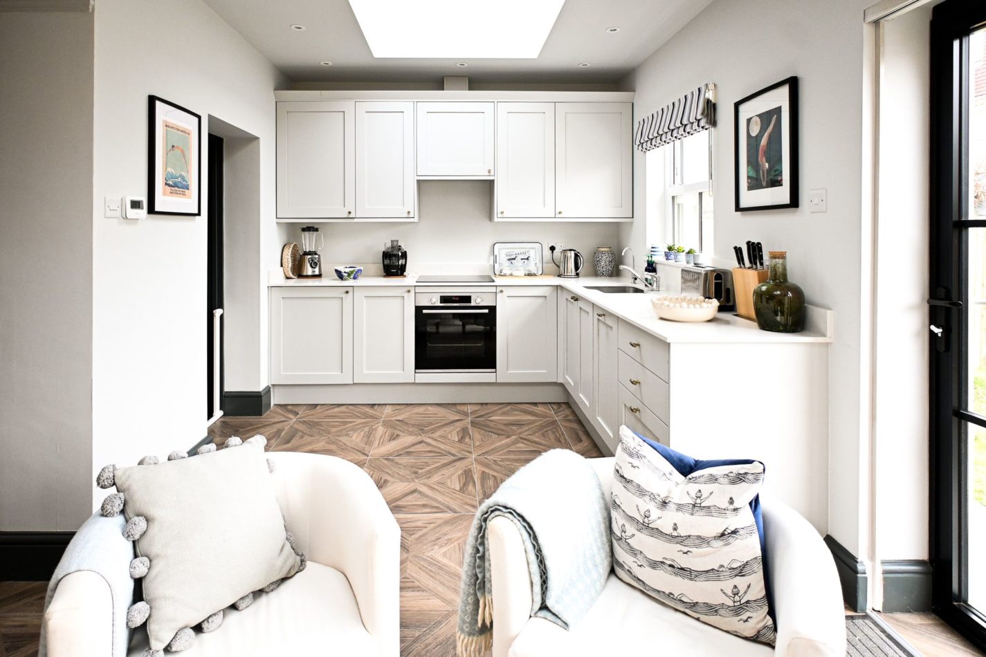 With its fresh white cabinetry and generous worktops, the kitchen makes preparing meals a pleasure, whether you are cooking together or keeping things simple.