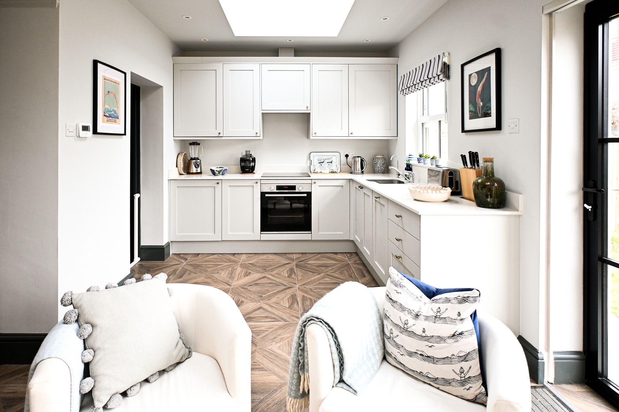 With its fresh white cabinetry and generous worktops, the kitchen makes preparing meals a pleasure, whether you are cooking together or keeping things simple.
