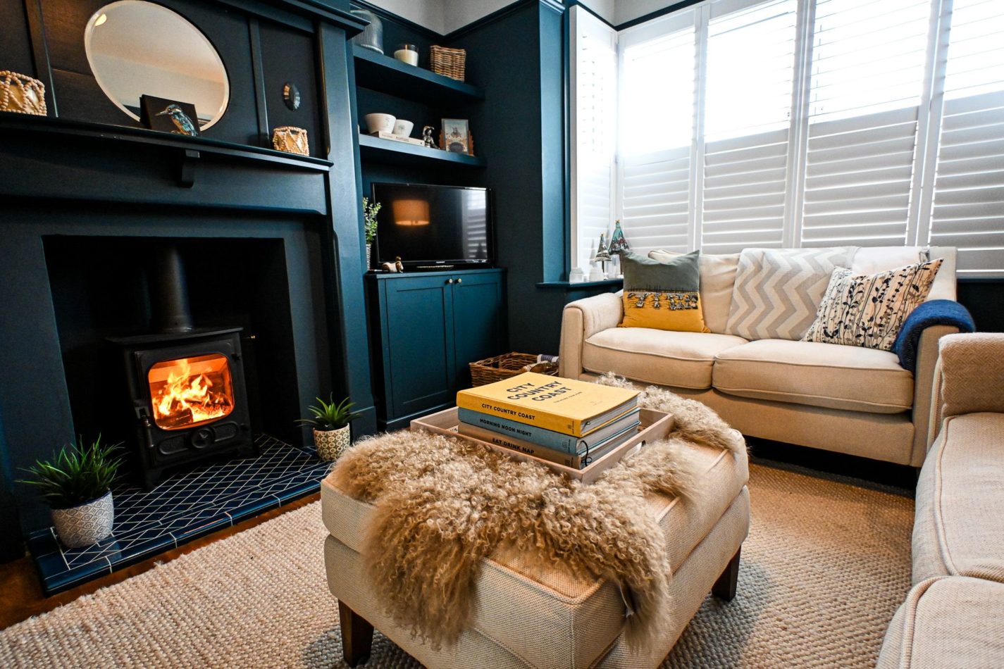 Cosy up beside the log burner after a blustery walk along Hythe seafront, with soft furnishings and comfortable seating creating a welcoming winter retreat.