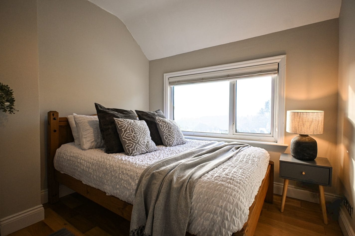 A peaceful bedroom with soft neutral furnishings, natural light and a comfortable double bed, perfect for a lazy morning before heading out to discover the surrounding countryside and coast.