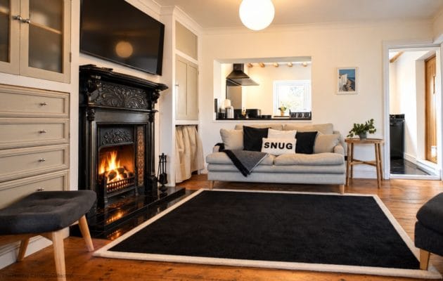 Settle into this cosy and inviting living room, where a beautiful ornate fireplace, comfortable sofa and warm wooden floors create the perfect setting to relax, unwind and enjoy a peaceful evening by the fire.